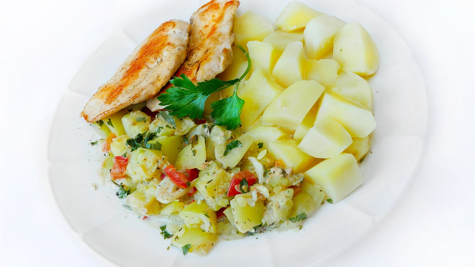 Plate of grilled chicken with potatoes and vegetables
